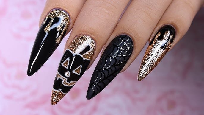 Halloween nails with a gold and black color combination.