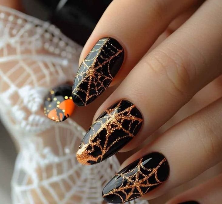 Gold and black Halloween nails with spooky patterns.